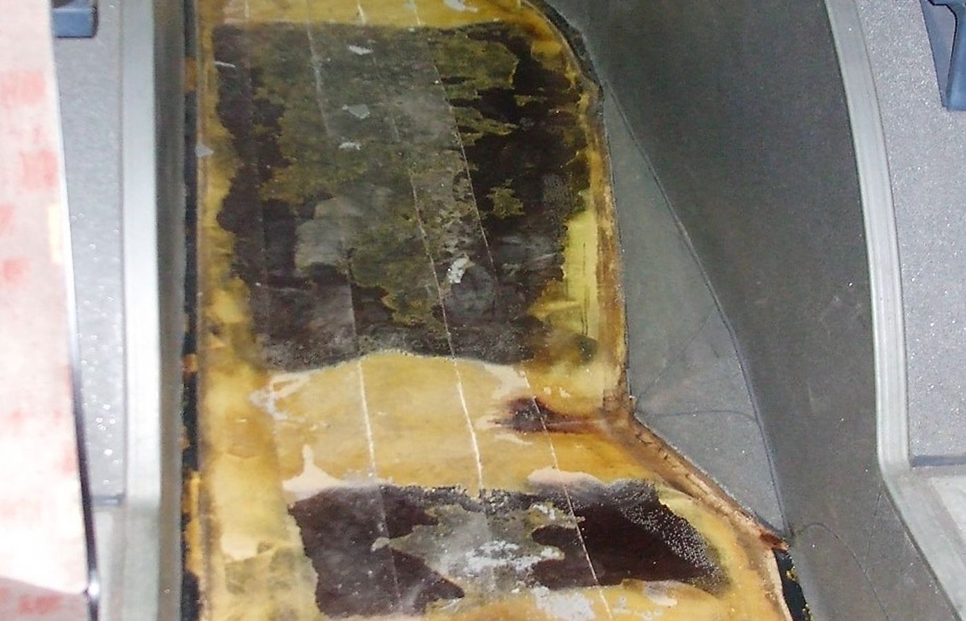 Freigelegter Fahrzeugboden mit durchfeuchteten Siebdruckplatten